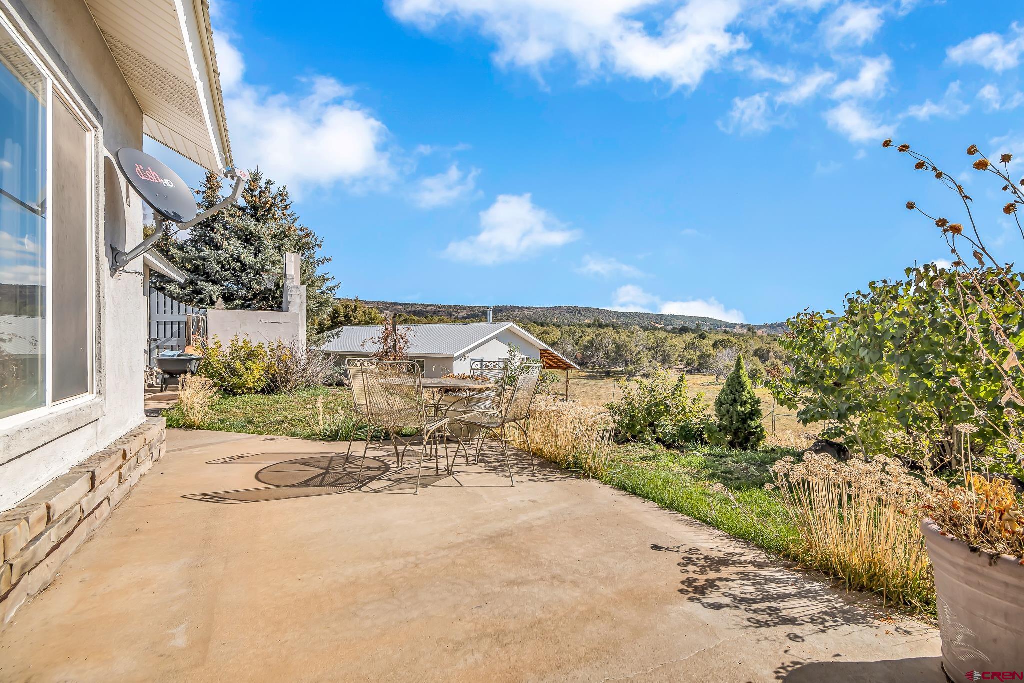 24344 Ute Trail Road Cedaredge, CO 81413 - Photo 7 of 33 a view of a garden with a building in the background