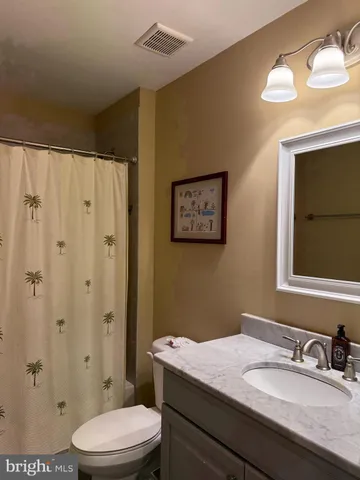 a bathroom with a granite countertop sink toilet a mirror and shower
