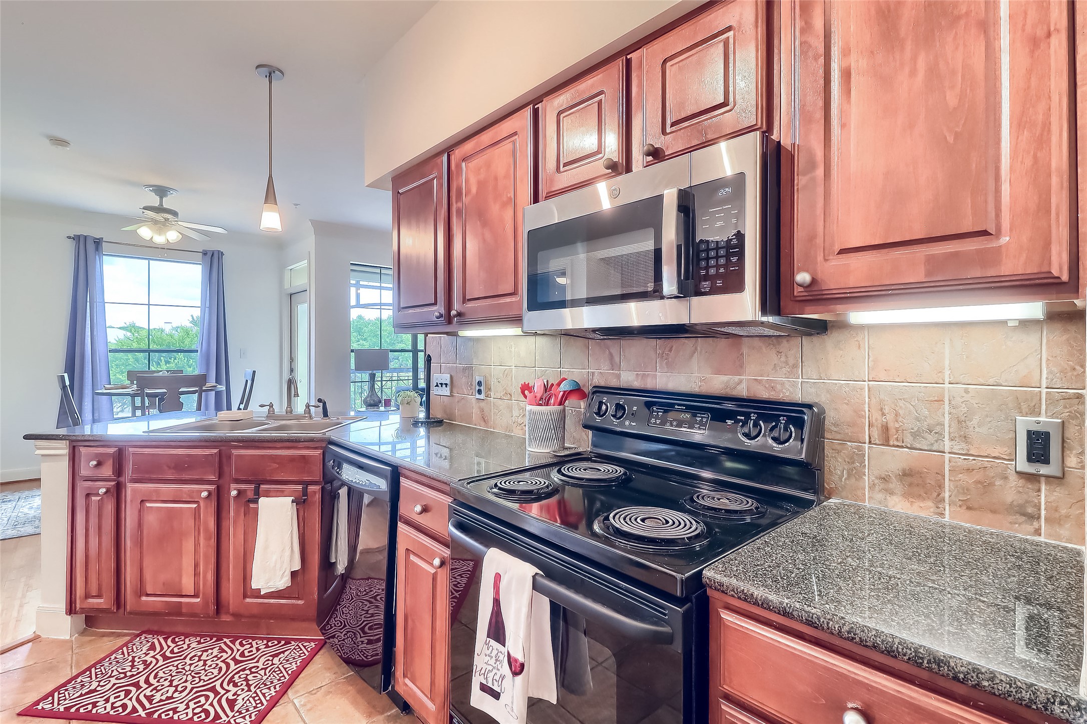 7701 Rialto Boulevard, Unit 1128 Austin, TX 78735 - Photo 7 of 35 a kitchen with stainless steel appliances granite countertop a stove a sink and a microwave