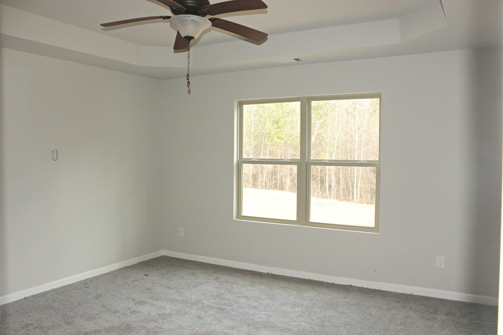 821 Weldon Road Forsyth, GA 31029 - Photo 5 of 8 an empty room with a window and a fan