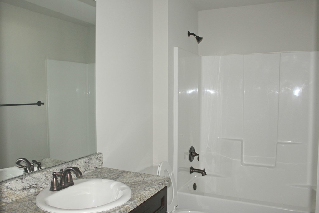 821 Weldon Road Forsyth, GA 31029 - Photo 7 of 8 a bathroom with a granite countertop sink a toilet and shower