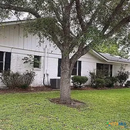 a front view of house with a garden