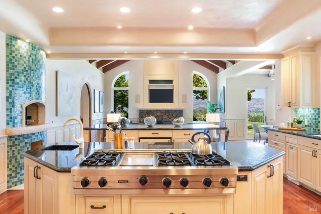 a kitchen with stainless steel appliances granite countertop a stove and a wooden floors