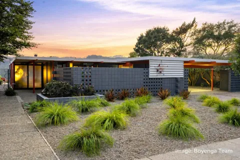 a front view of a house with a garden