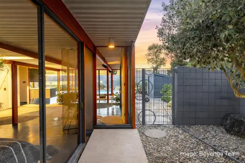 a living room with patio furniture and a floor to ceiling window