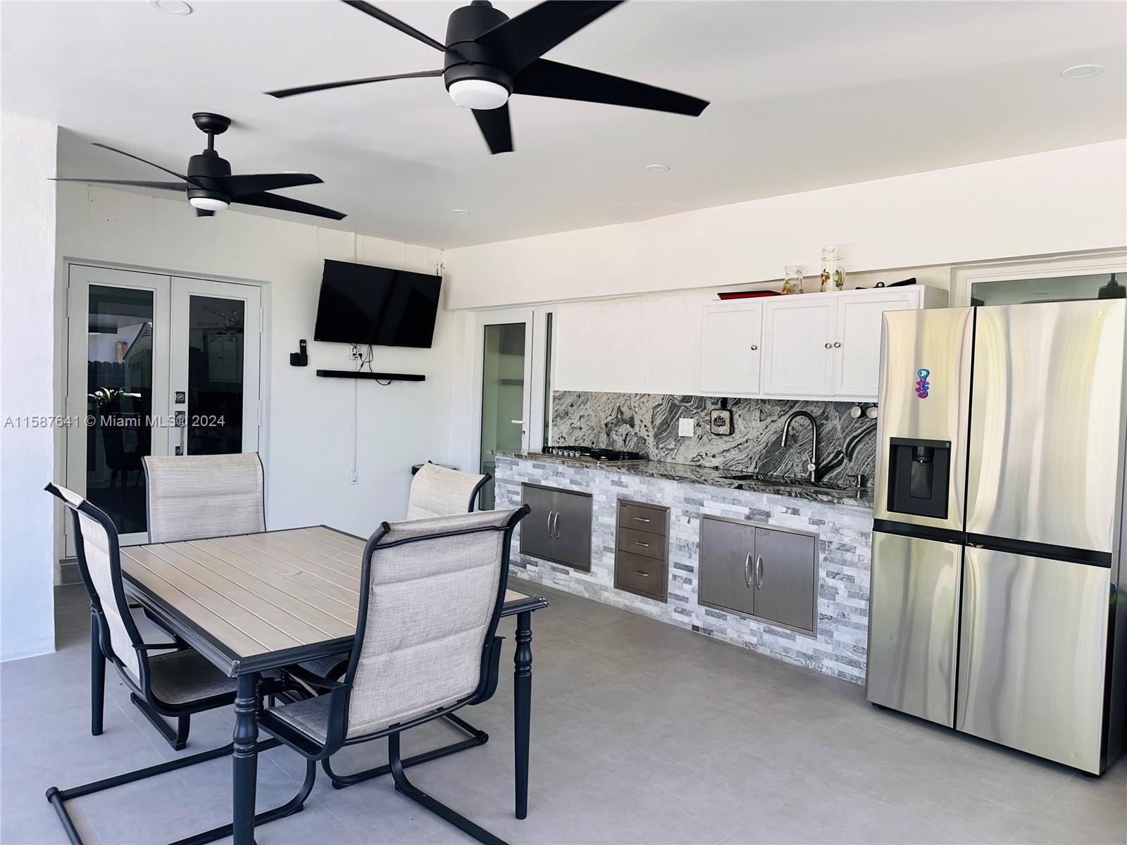 17841 Southwest 113th Avenue Miami, FL 33157 - Photo 15 of 23 a kitchen with stainless steel appliances granite countertop a stove a sink dishwasher a dining table and chairs with wooden floor