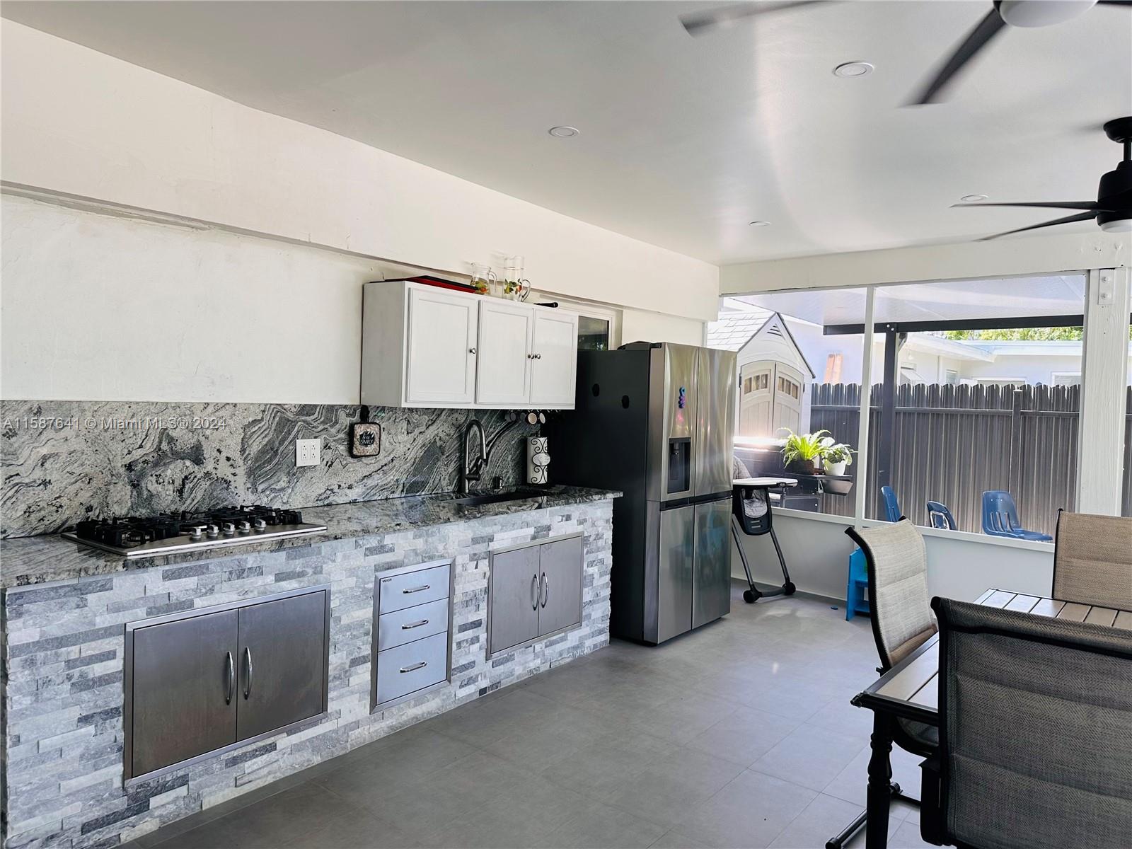 17841 Southwest 113th Avenue Miami, FL 33157 - Photo 16 of 23 a kitchen with stainless steel appliances granite countertop a stove top oven a sink dishwasher a dining table and chairs with wooden floor