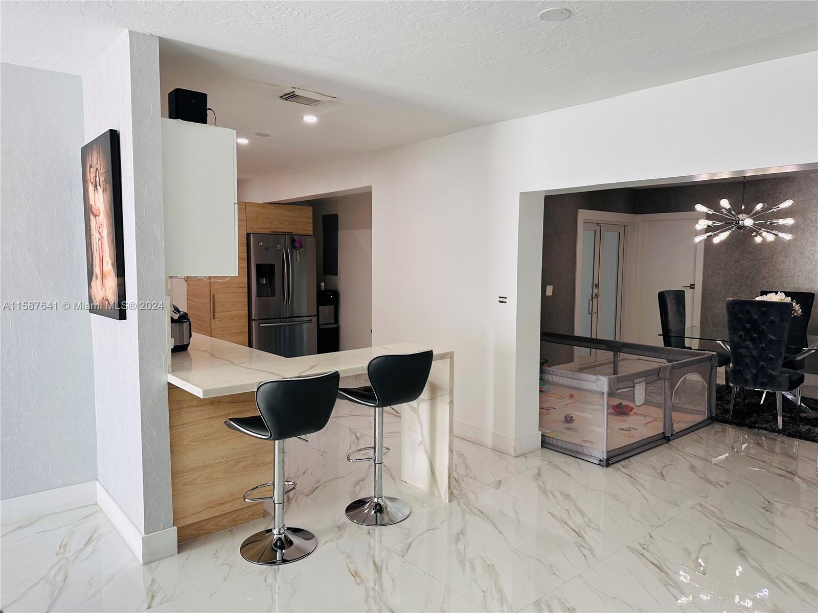 17841 Southwest 113th Avenue Miami, FL 33157 - Photo 5 of 23 a living room with furniture and a chandelier