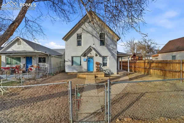 a view of a house with wooden fence