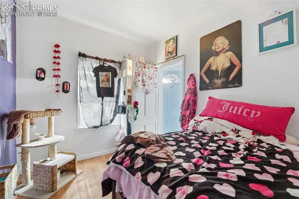 a bedroom with a bed and wooden floor