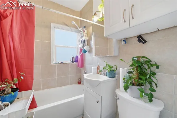 a bathroom with a bathtub a sink a toilet and shower