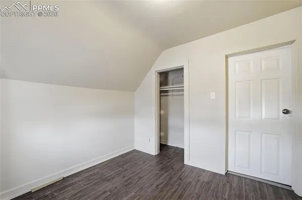 a view of empty room with wooden floor
