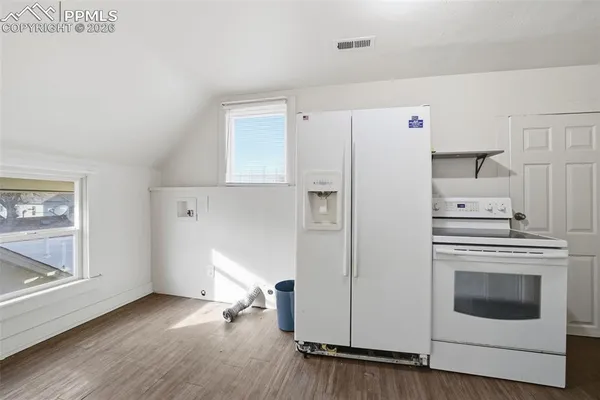 a kitchen with a white stove refrigerator and a microwave