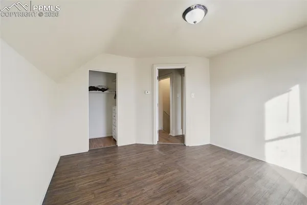 a view of empty room with wooden floor