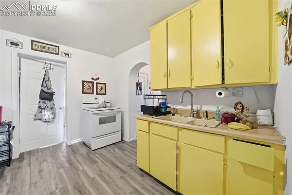 a kitchen with a sink cabinets and wooden floor