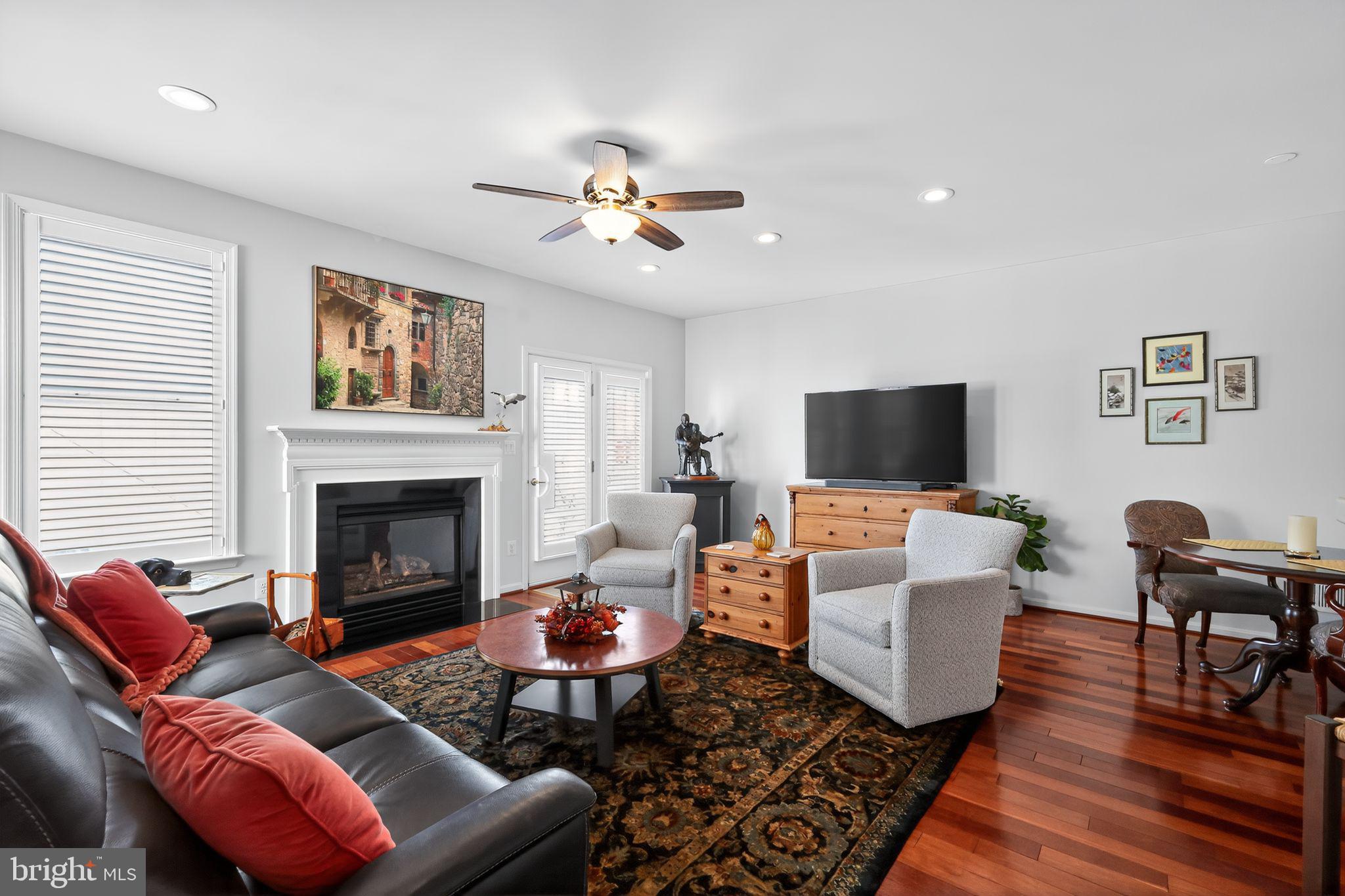 6013 Piney Grove Way Gainesville, VA 20155 - Photo 12 of 41 a living room with furniture a flat screen tv and a fireplace
