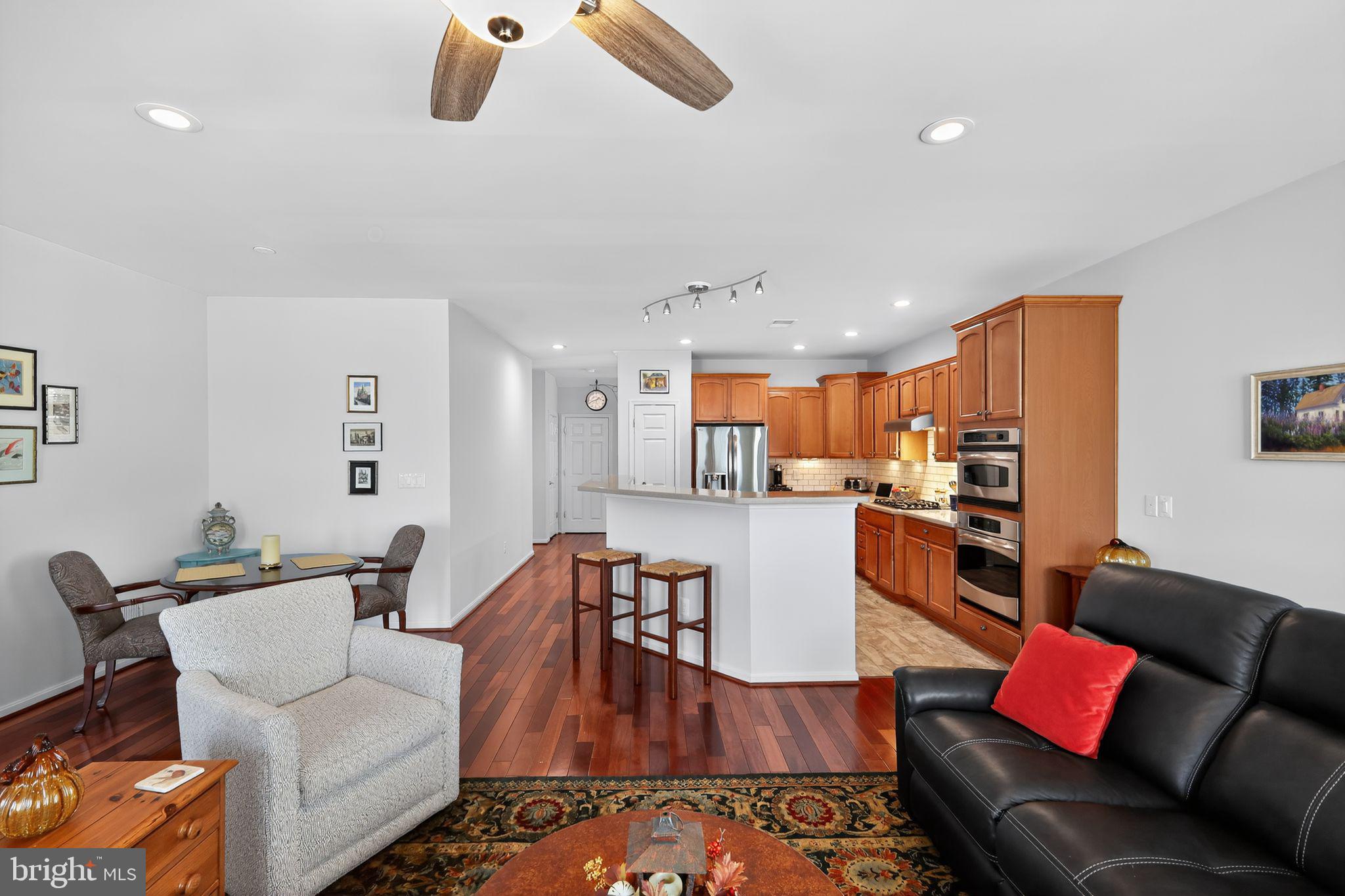 6013 Piney Grove Way Gainesville, VA 20155 - Photo 7 of 41 a living room with furniture kitchen view and a wooden floor