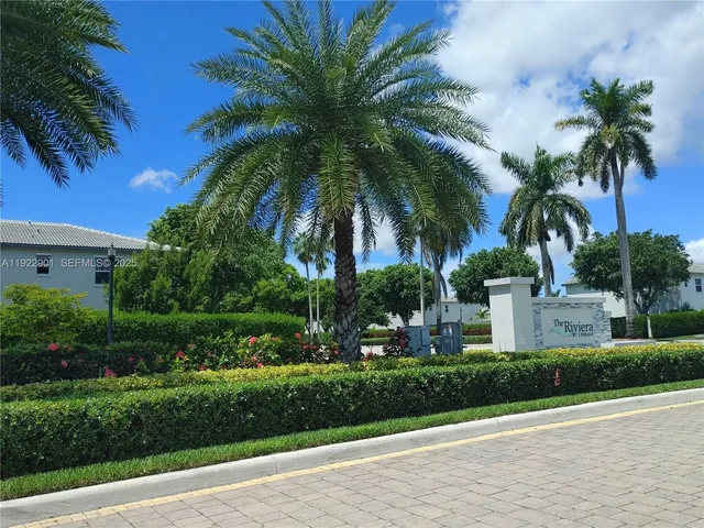 a backyard of a house with table and chairs plants and large tree