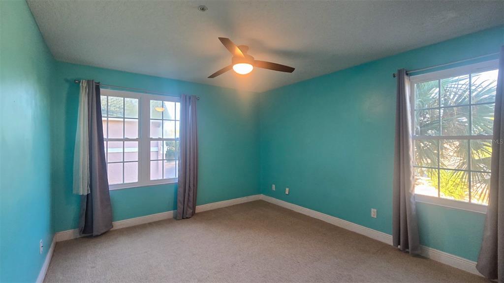 7667 North Wickham Road, Unit 522 Melbourne, FL 32940 - Photo 13 of 25 an empty room with chandelier fan and windows