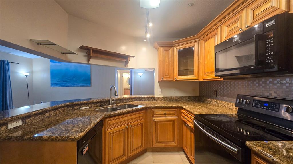 7667 North Wickham Road, Unit 522 Melbourne, FL 32940 - Photo 3 of 25 a kitchen with stainless steel appliances granite countertop a sink and a stove