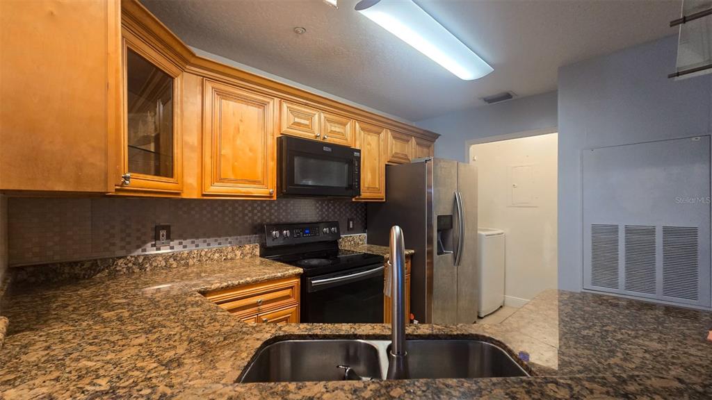 7667 North Wickham Road, Unit 522 Melbourne, FL 32940 - Photo 5 of 25 a kitchen with a sink and a stove top oven