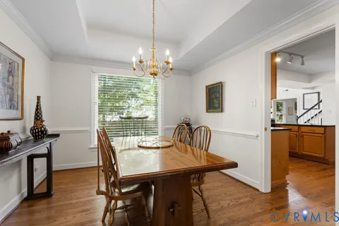 a view of a a dining room with furniture window and wooden floor