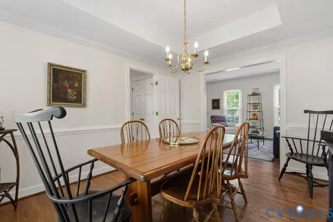 a kitchen with granite countertop a stove top oven a sink dishwasher a dining table and chairs with wooden floor