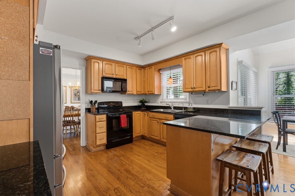 3009 Sable Road Henrico, VA 23233 - Photo 13 of 51 a kitchen with granite countertop a stove top oven a sink dishwasher a dining table and chairs with wooden floor