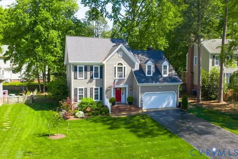 a front view of a house with a yard and trees