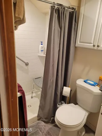 a white toilet sitting next to a shower