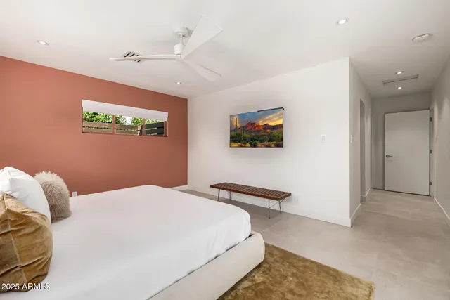 a bedroom with a large bed and a chandelier