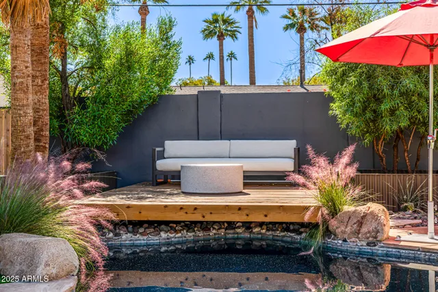 a view of a house with backyard sitting area and swimming pool