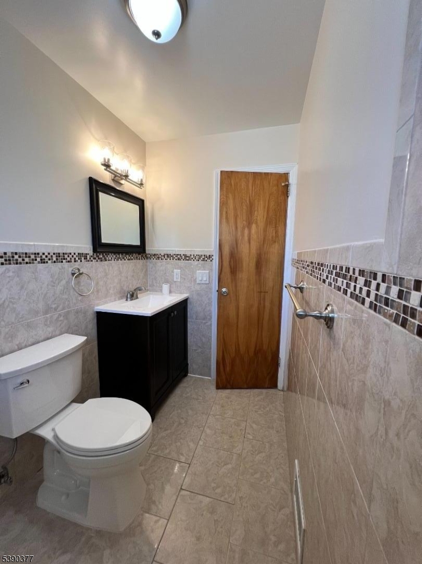 1575 Lenox Place, Unit 2 Rahway, NJ 07065 - Photo 8 of 12 a bathroom with a toilet sink vanity and mirror