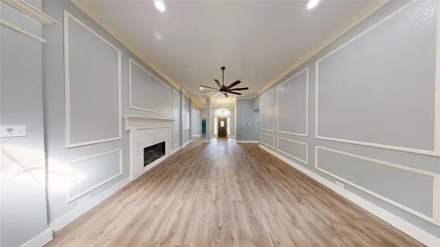 a view of a hallway with wooden floor fireplace and a window