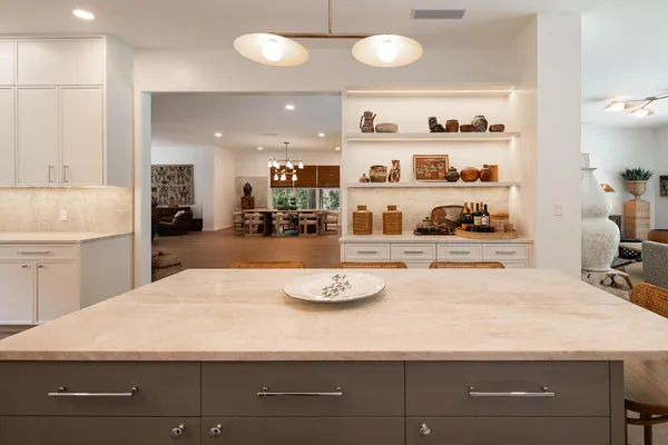 a kitchen with a sink a stove and white cabinets with wooden floor