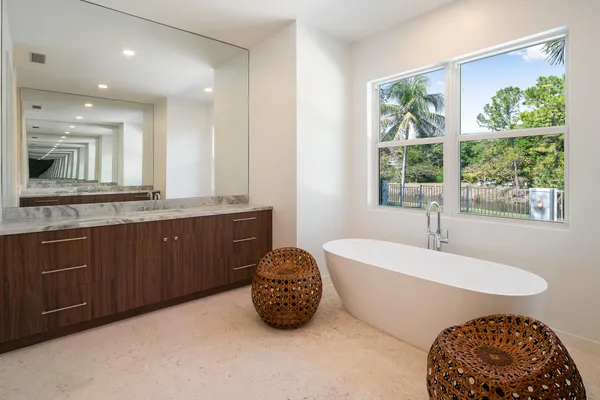 a spacious bathroom with a double vanity sink a mirror and a bathtub