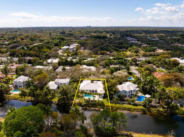 an aerial view of residential houses with outdoor space and lake view