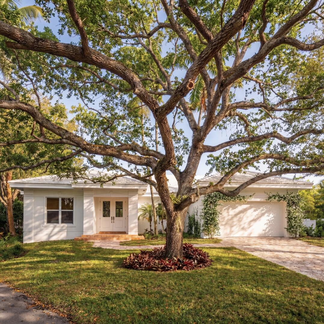 6371 Southwest 87th Terrace Pinecrest, FL 33156 - Photo 3 of 16 a backyard of a house with table and chairs