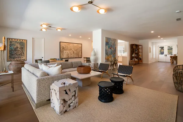 a living room with furniture a large window and gym equipment