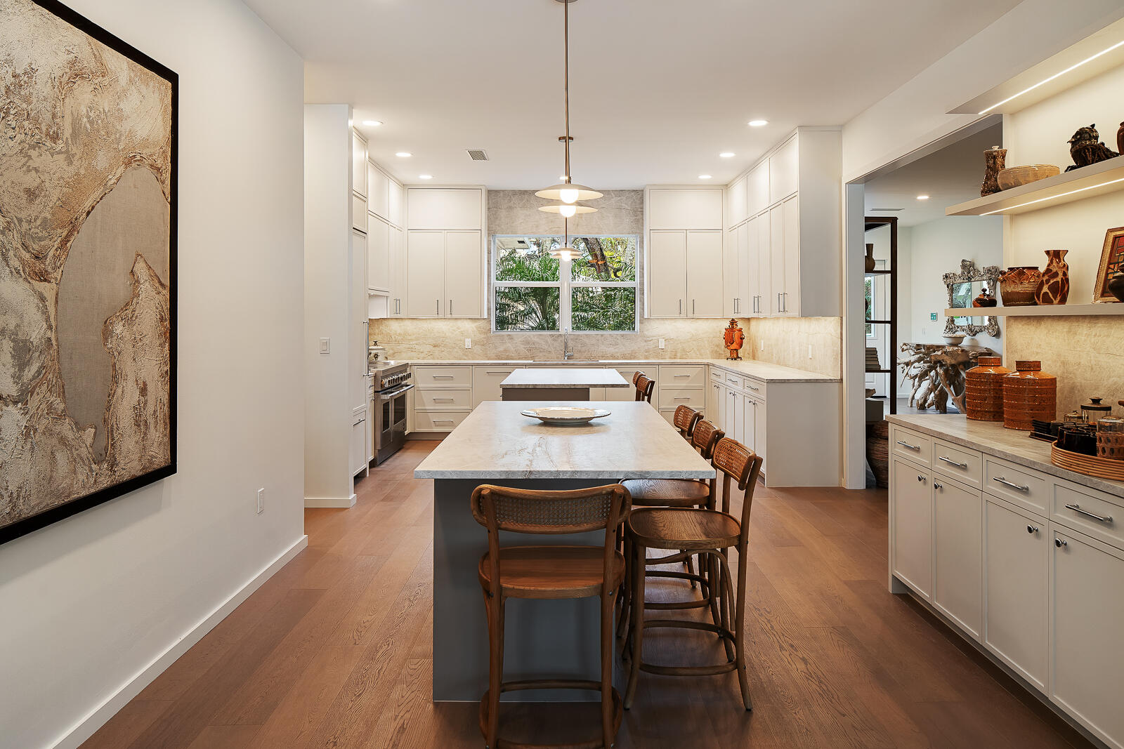 6371 Southwest 87th Terrace Pinecrest, FL 33156 - Photo 9 of 16 a kitchen with stainless steel appliances a dining table chairs and wooden floor
