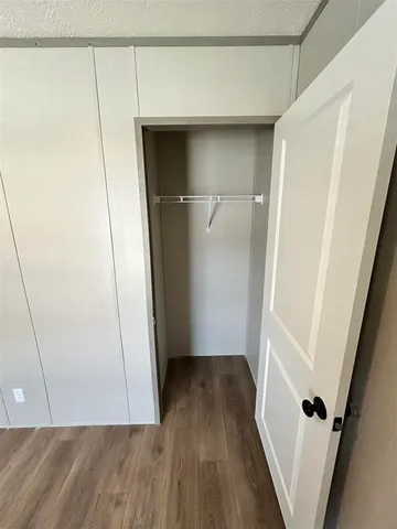 a view of walk in closet with wooden floor