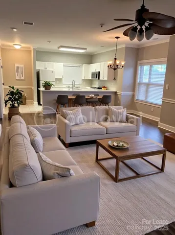 a living room with furniture and a chandelier