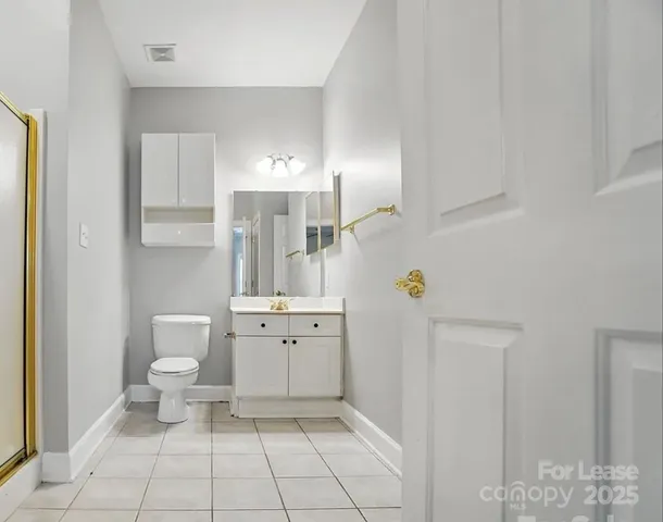 a bathroom with a toilet mirror and vanity