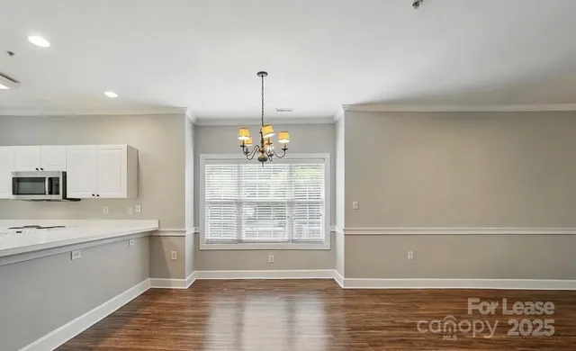 a view of a kitchen with a sink and dishwasher with wooden floor