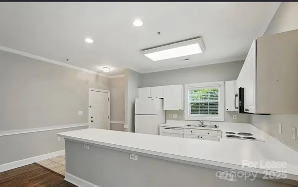 a large white kitchen with a large window