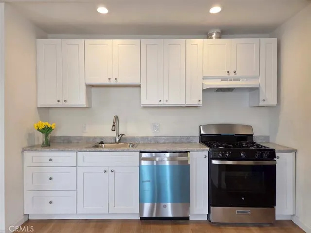 a kitchen with white cabinets and appliances