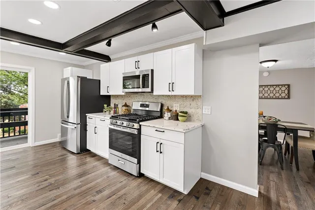a kitchen with a stove a refrigerator and a microwave