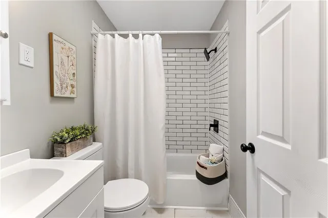 a bathroom with a toilet and shower curtain