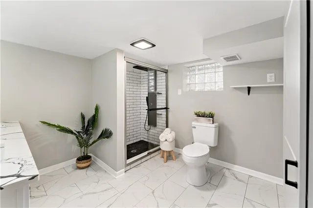 a bathroom with a toilet and a shower