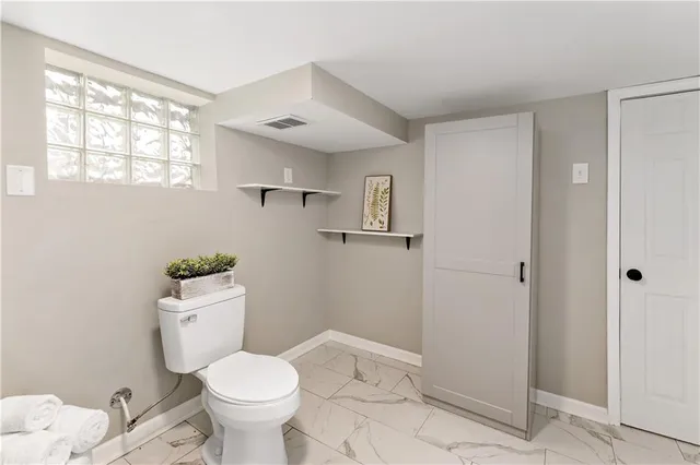 a white toilet sitting next to a bathroom sink and vanity